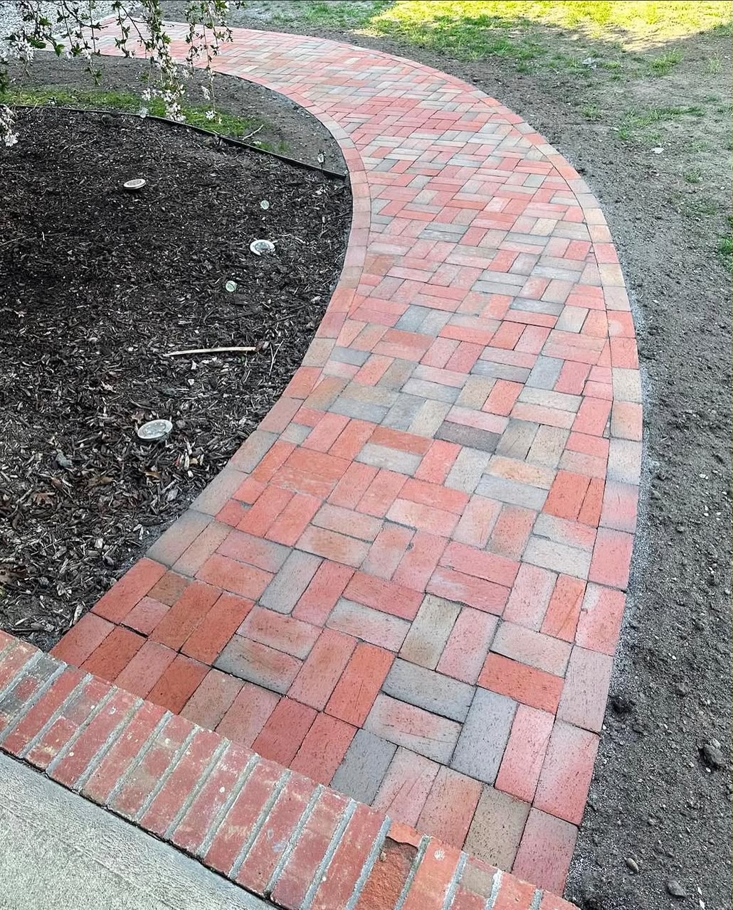 Curved paver walkway installed through a landscaped Cape Cod yard