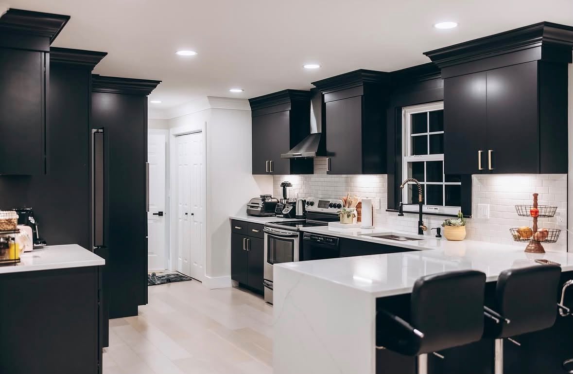 Custom black kitchen cabinetry with a large white island