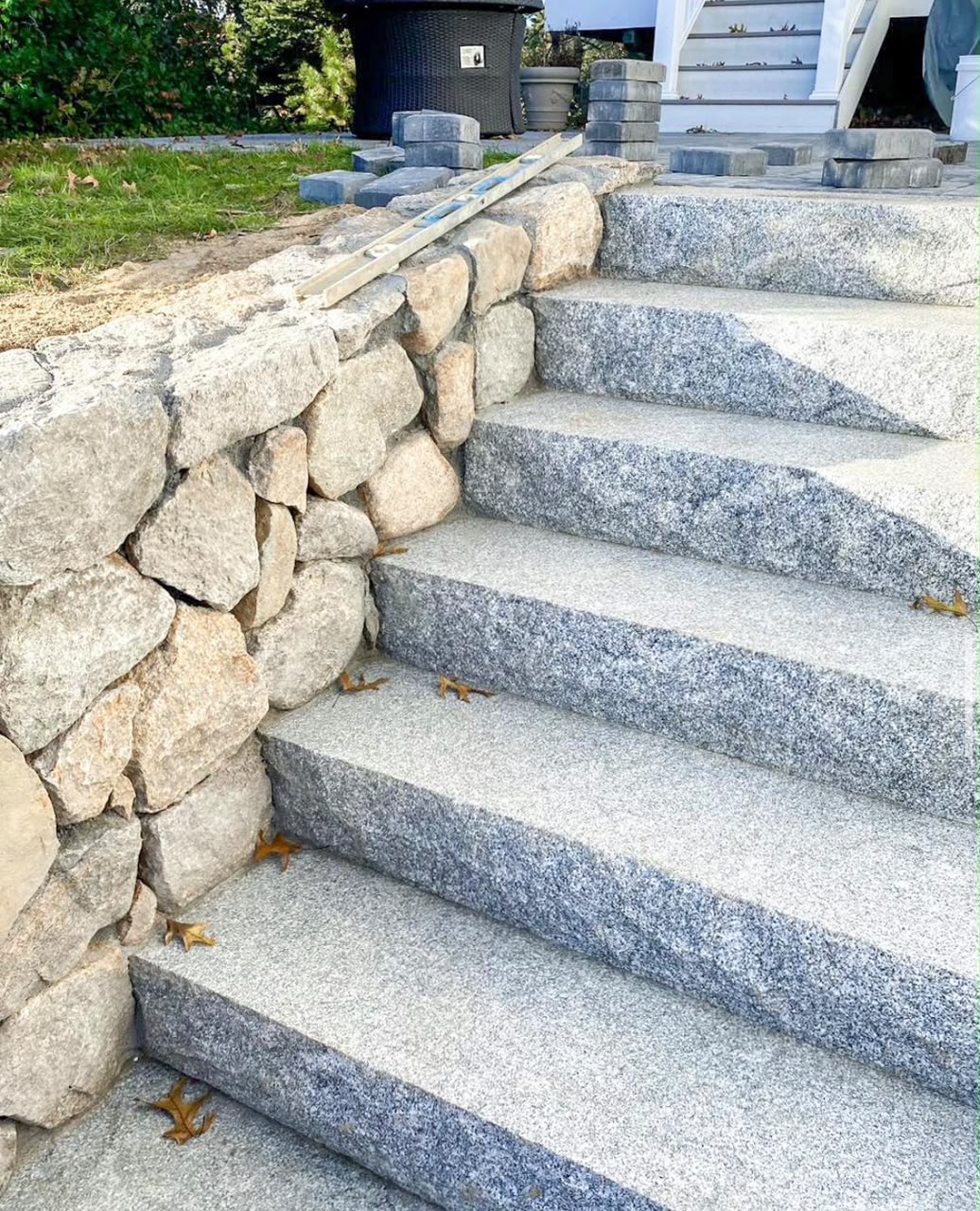 Granite entry steps built beside a natural stone wall