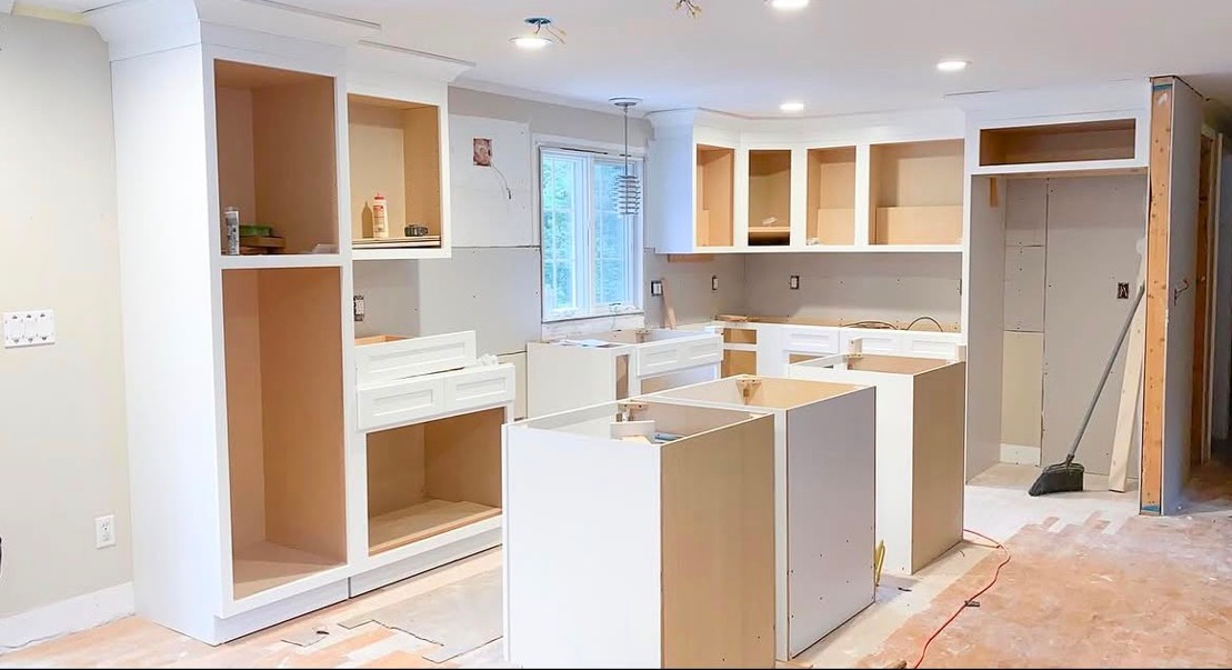 Kitchen cabinets being installed during a remodeling project in a Cape Cod home