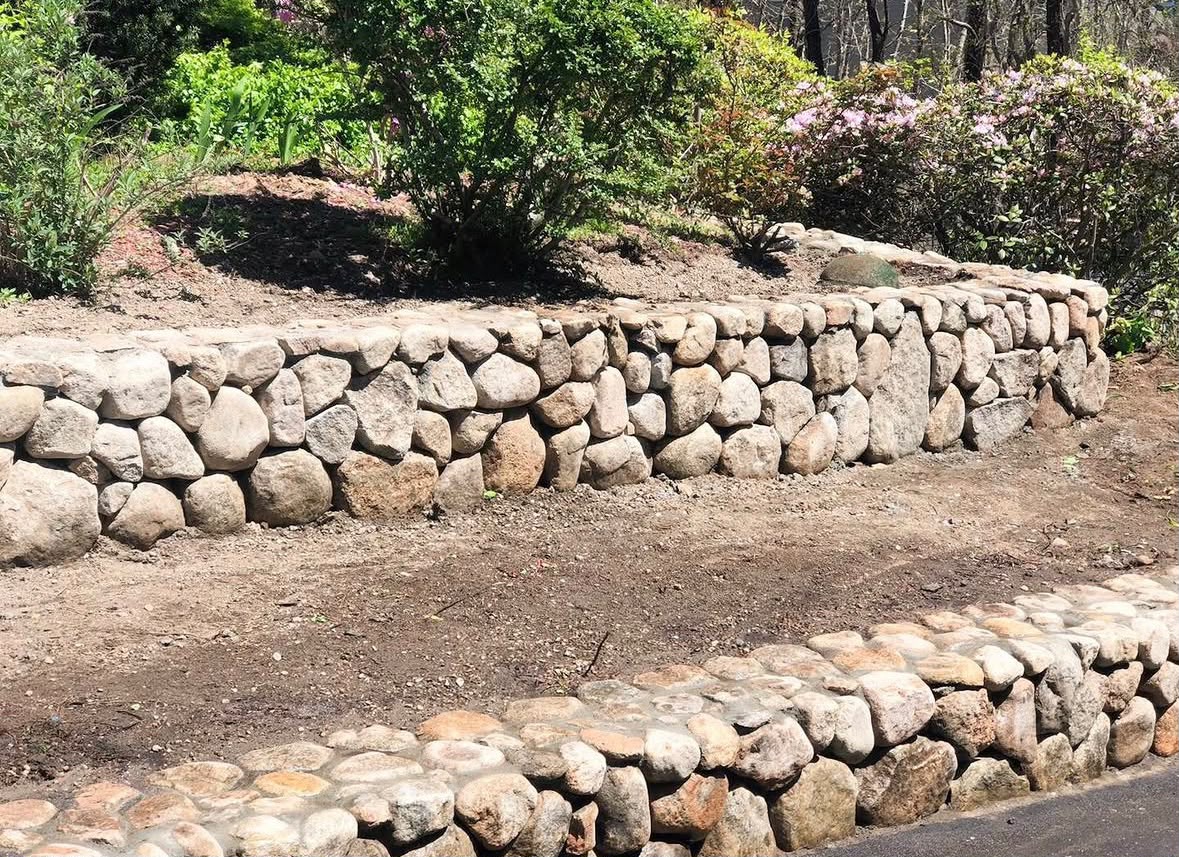 Completed natural stone retaining wall in Cape Cod